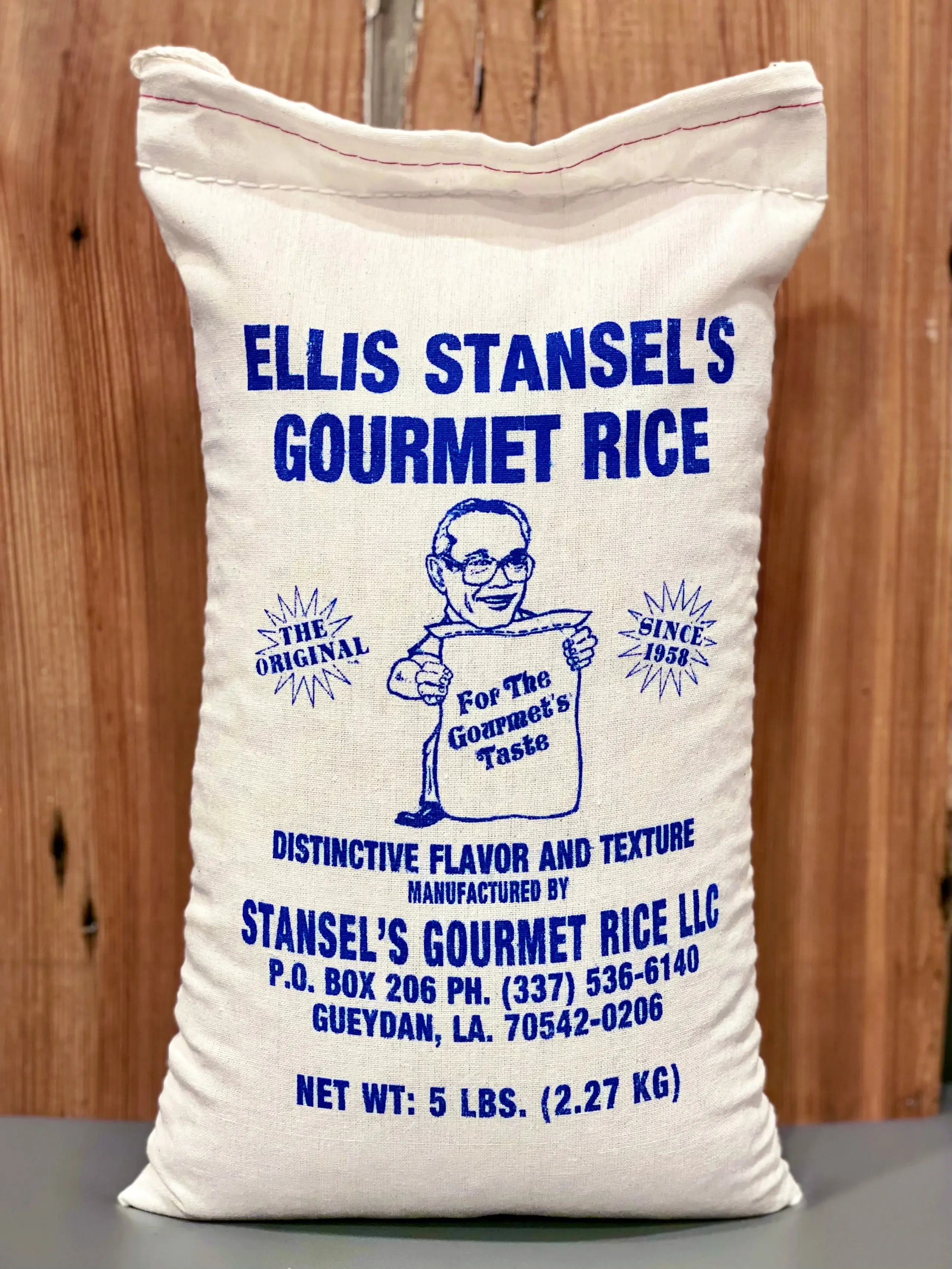 Vintage wooden sign advertising Ellis Stansel's Gourmet Rice with a smiling chef illustration.